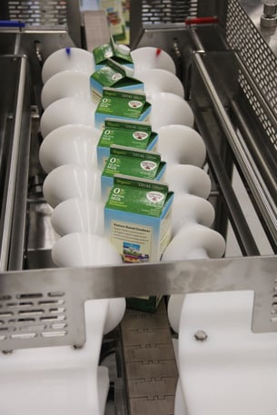 two timing screws turning milk cartons